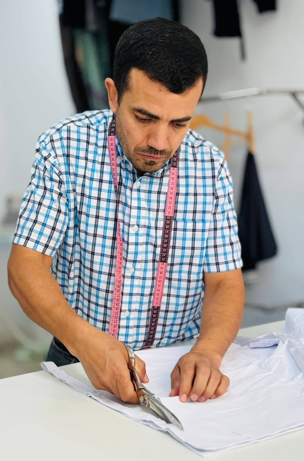 Larbi El Achiri cortando tejido a medida en el taller La Aguja de Oro en Avilés