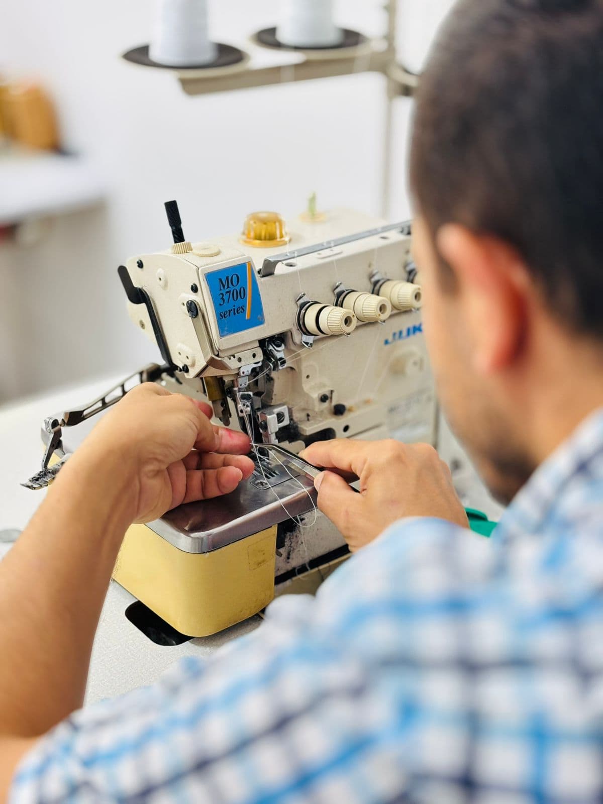 Larbi ajustando máquina industrial para arreglos textiles