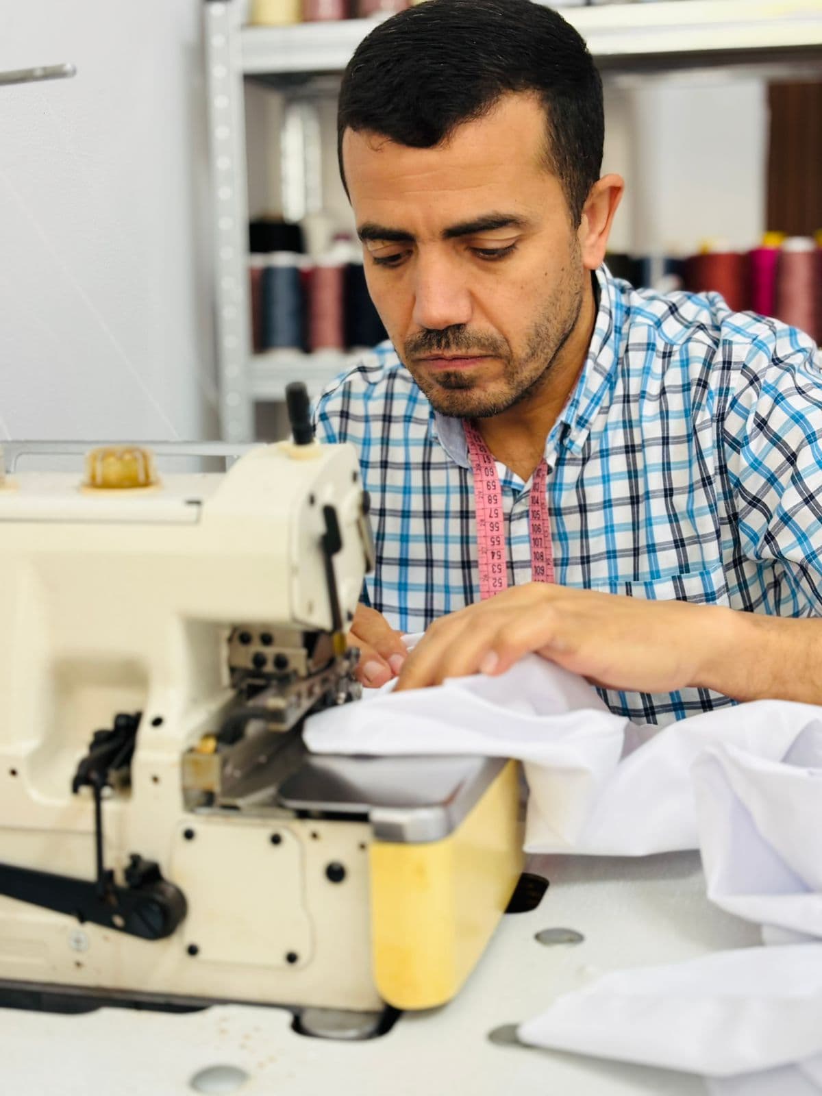 Larbi cosiendo prenda a máquina en La Aguja de Oro Avilés
